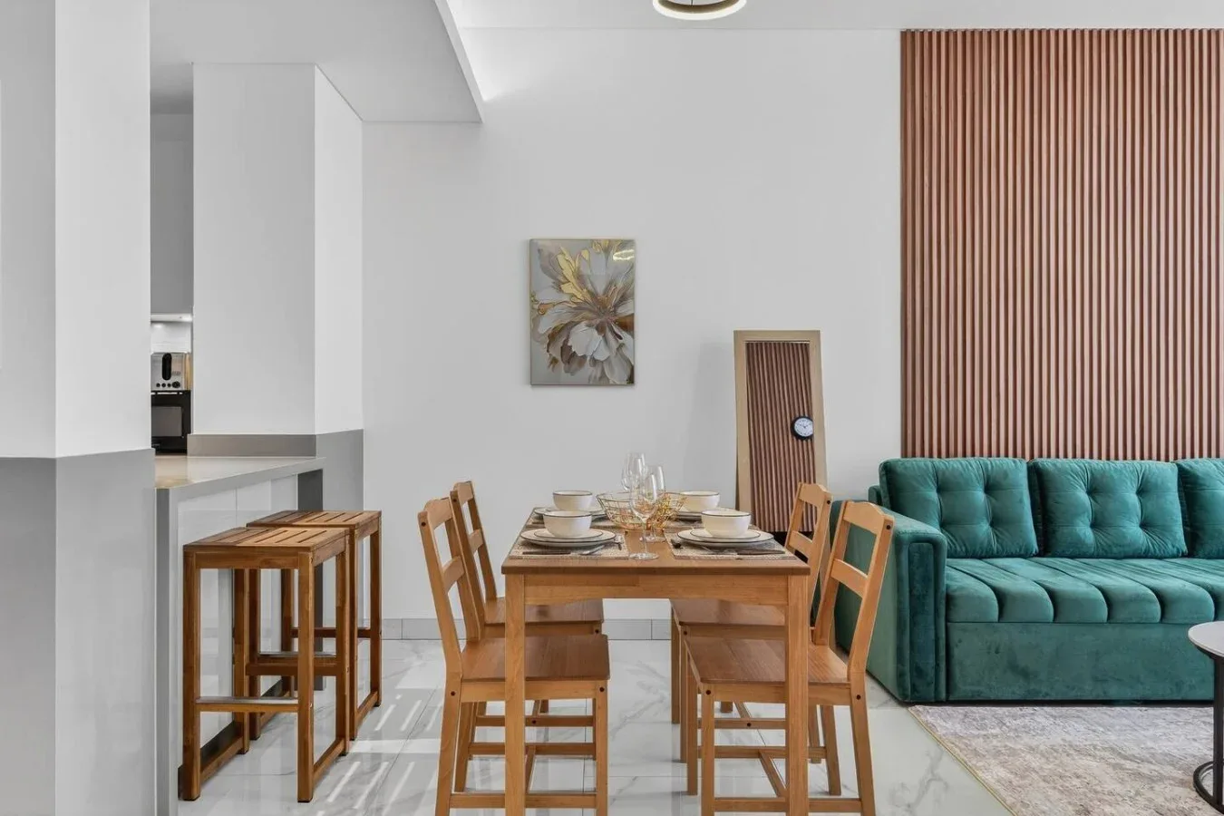 Comedor con una mesa y sillas de madera junto a un sofá verde azulado.