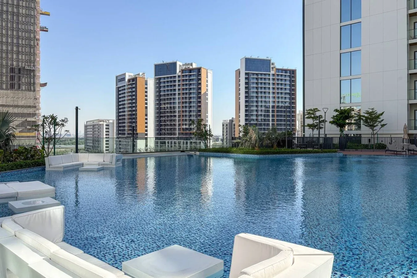 Una piscina al aire libre está rodeada de edificios altos modernos.