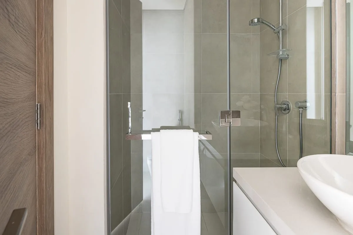 A modern bathroom with a glass shower and a white sink.