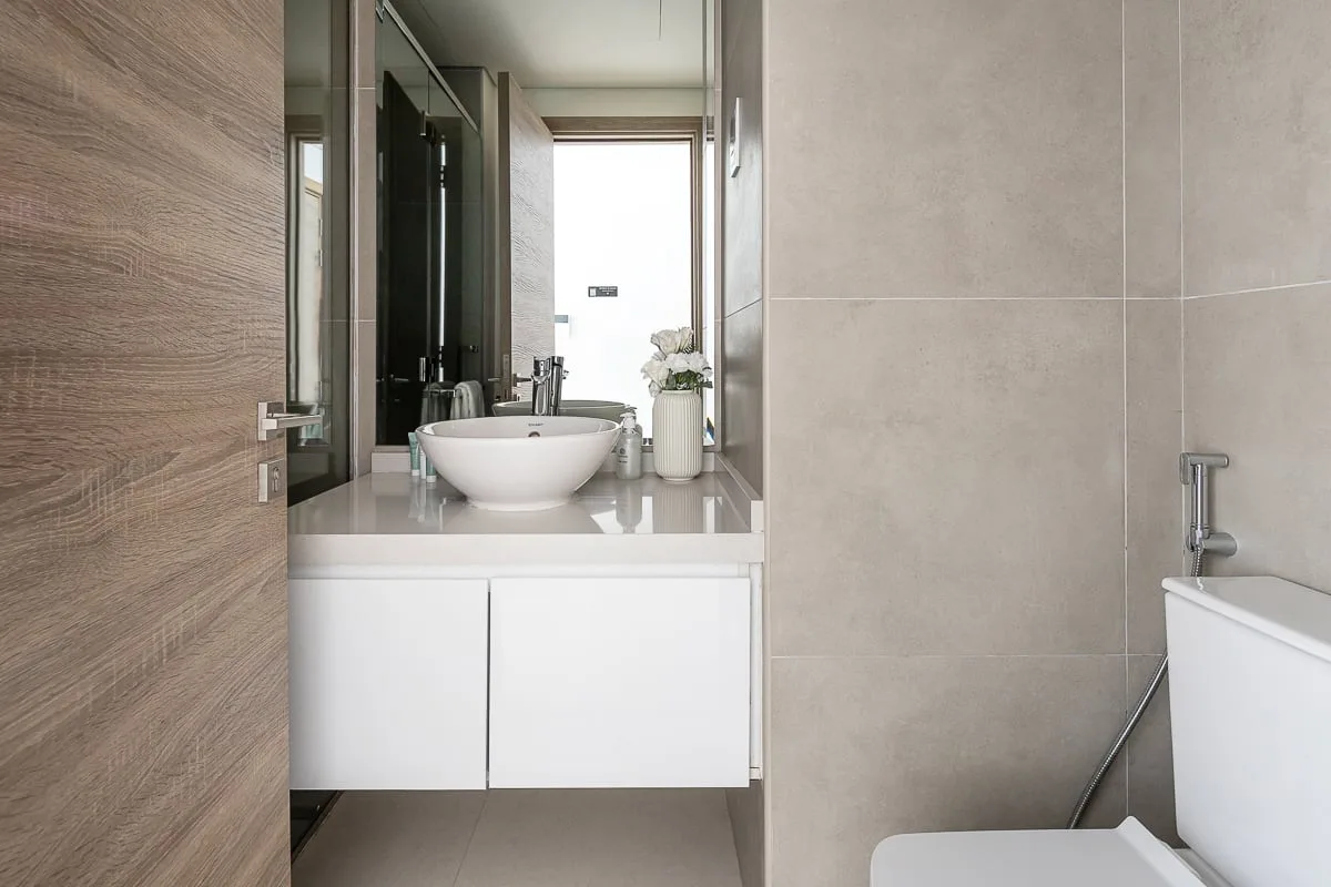 A modern bathroom with a sink, mirror, and bathtub.