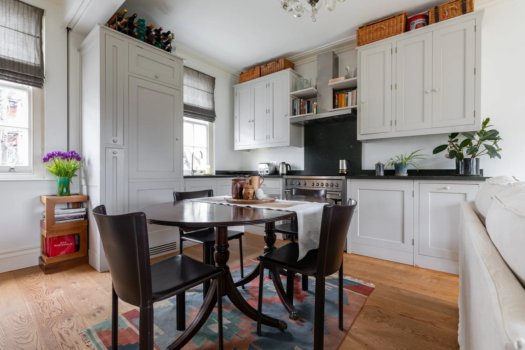 A bright kitchen and dining area with white cabinetry and a table.