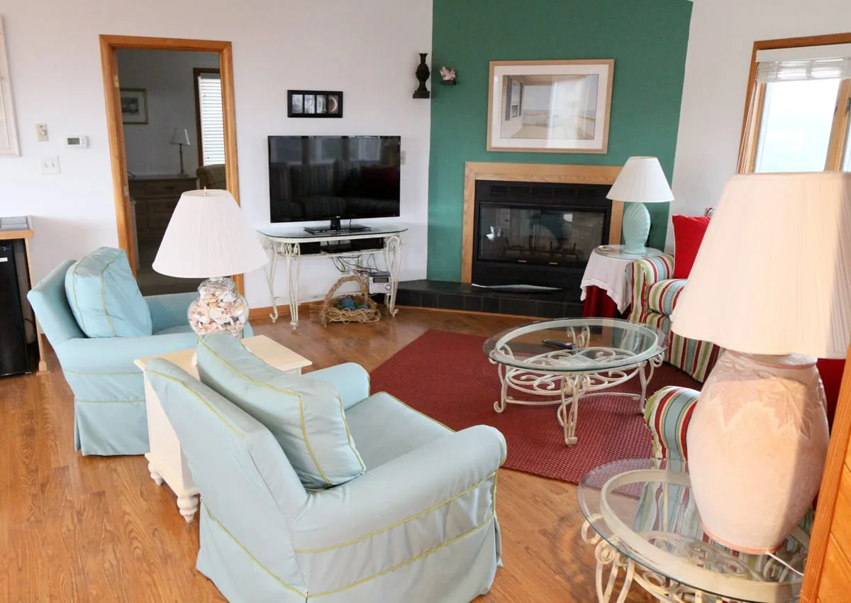 Una sala de estar con asientos, un televisor y una chimenea.