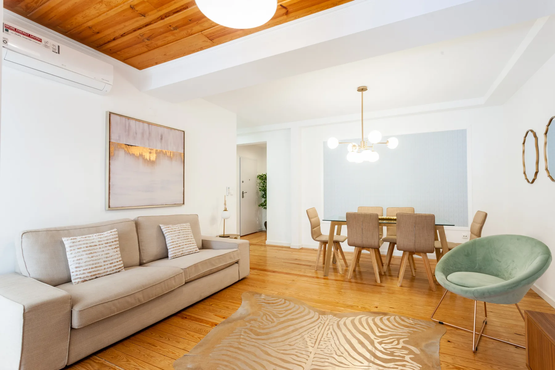Living and dining area with seating around a table and a green accent chair.