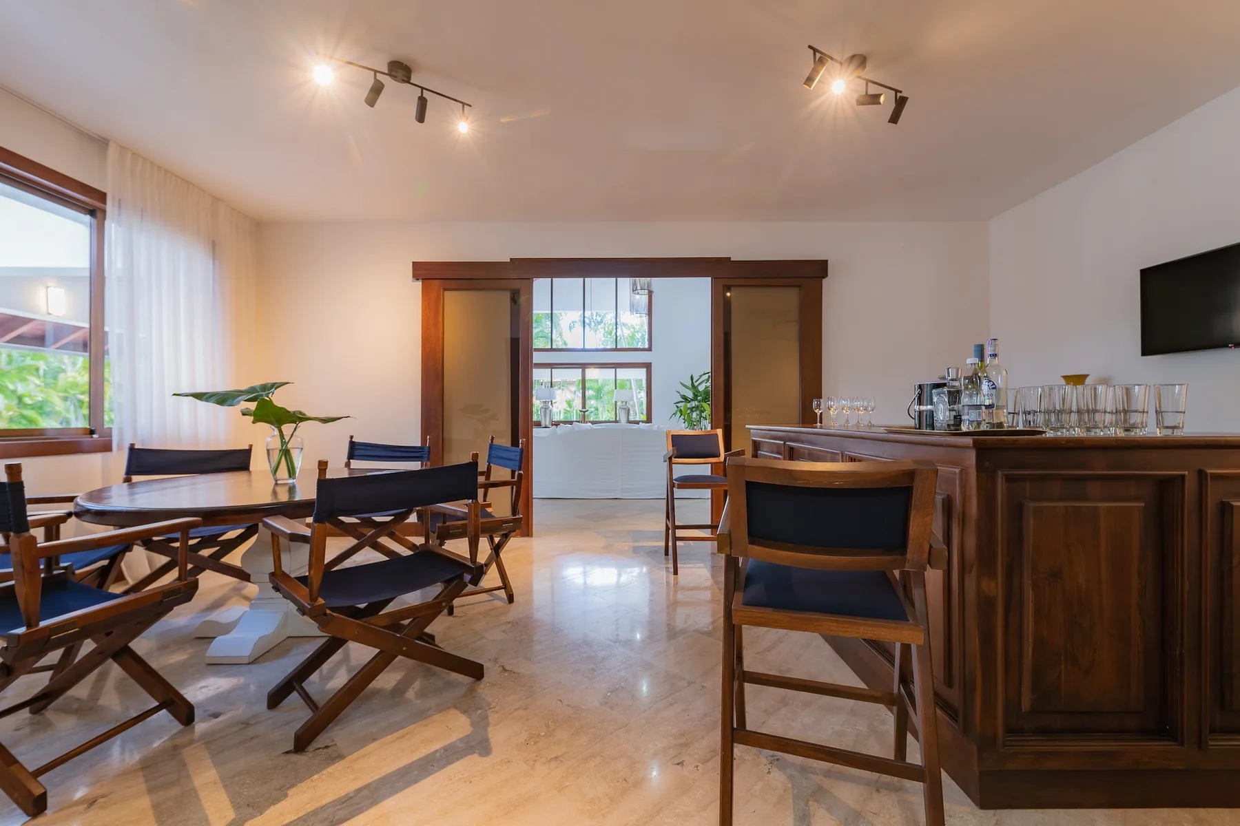 A dining area with a wooden table and chairs beside a bar counter.