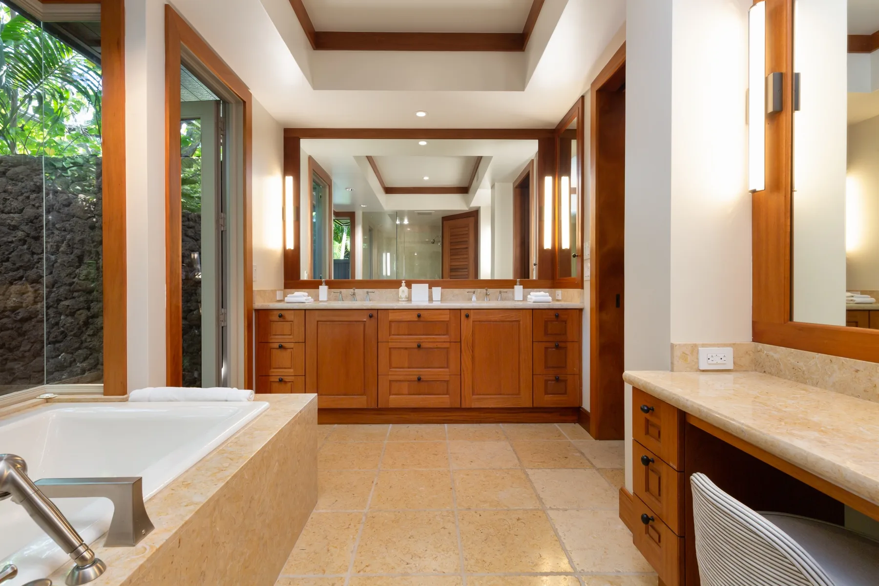 A bathroom with a bathtub, vanity, and large mirror.
