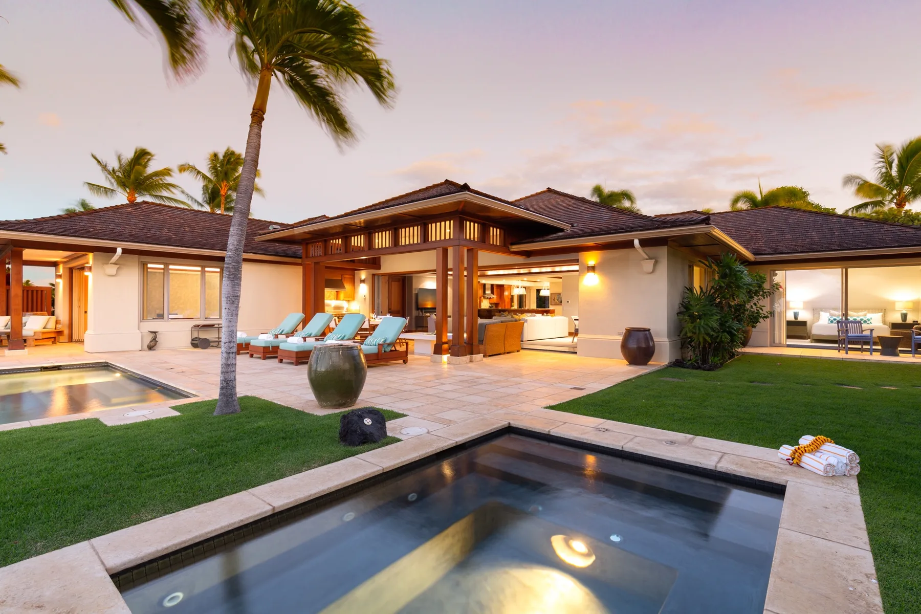 A low modern residence surrounds a courtyard with pools and outdoor seating.
