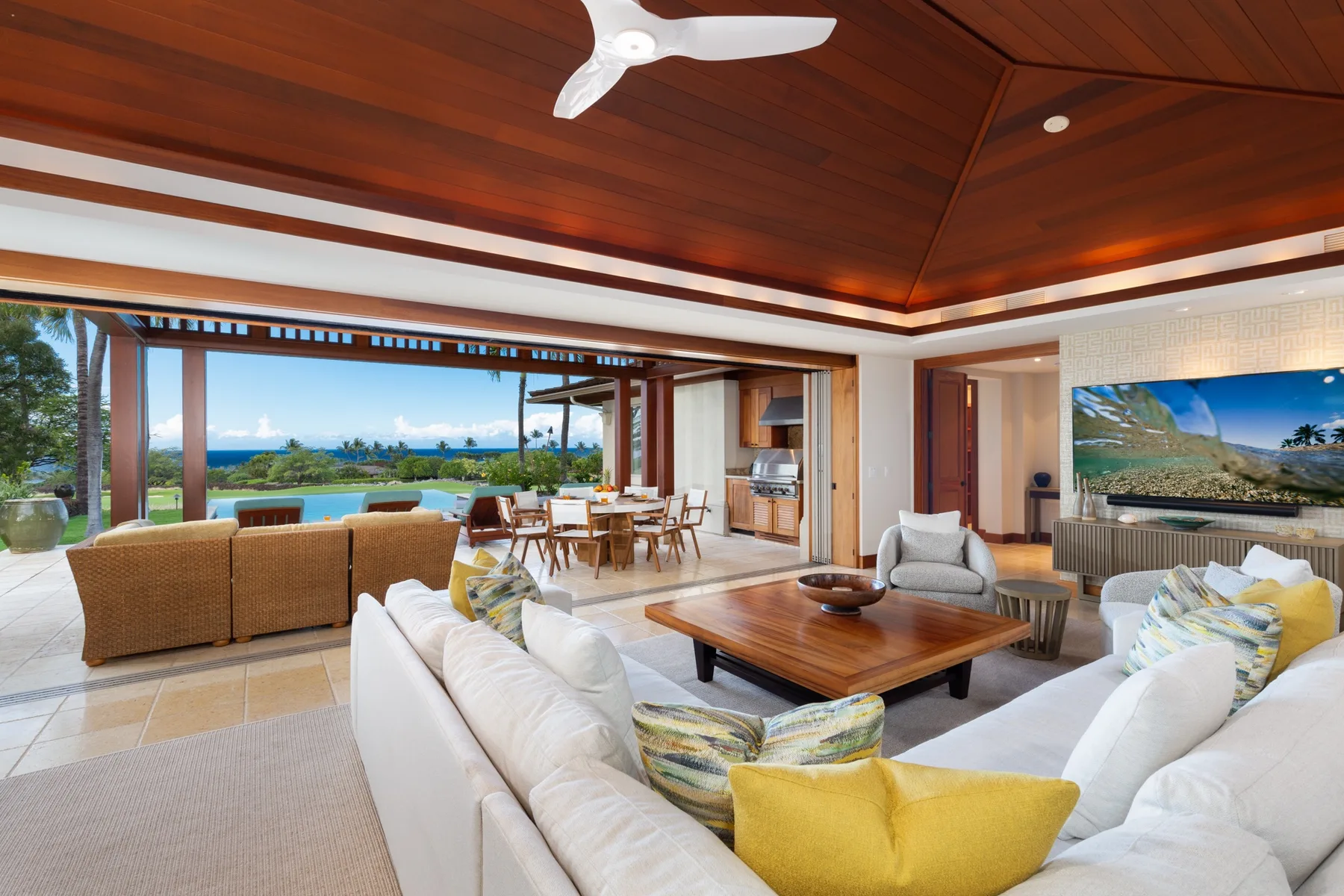 An open living and dining area with seating arranged around a wooden coffee table.