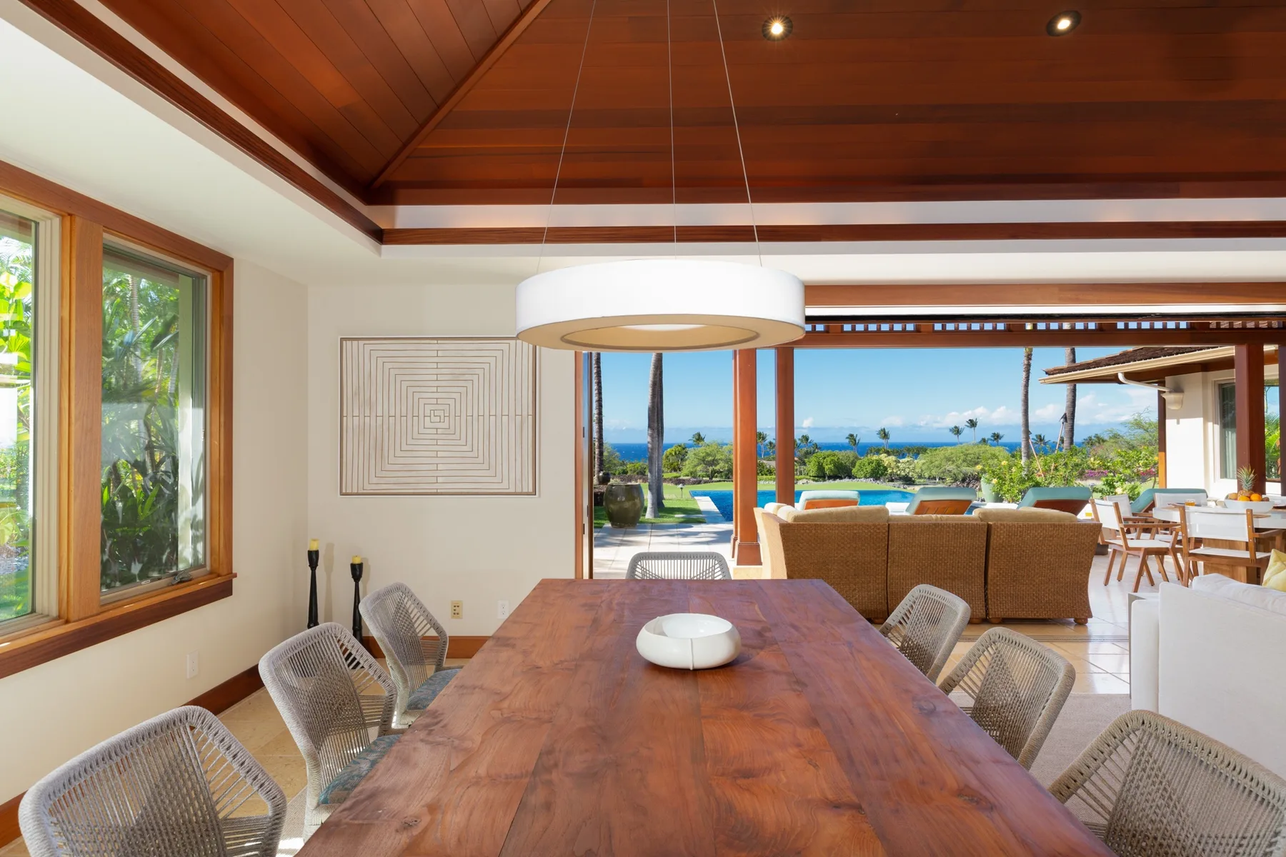 A dining area opens onto a patio with a view of the sea.