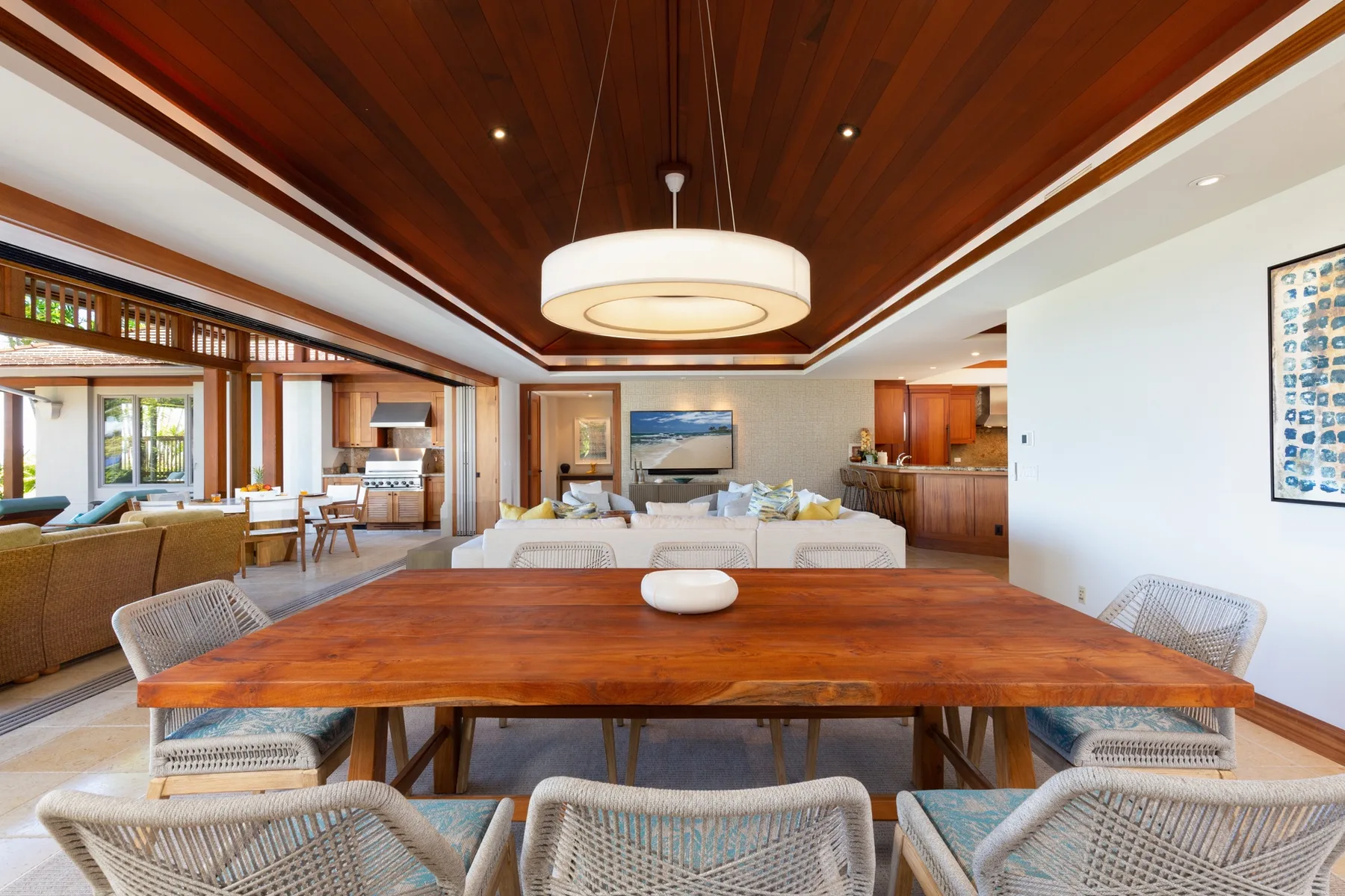 An open-plan living and dining room with a large wooden table in the foreground.