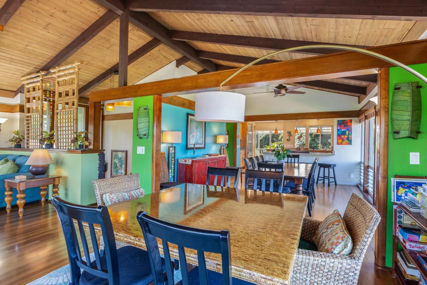 Una amplia sala de estar y comedor con techo de madera y muebles coloridos.