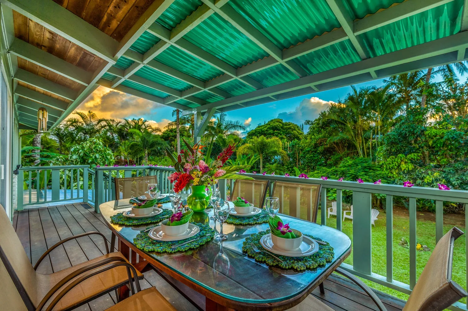 Una zona de comedor al aire libre y cubierta da a una exuberante vegetación tropical.
