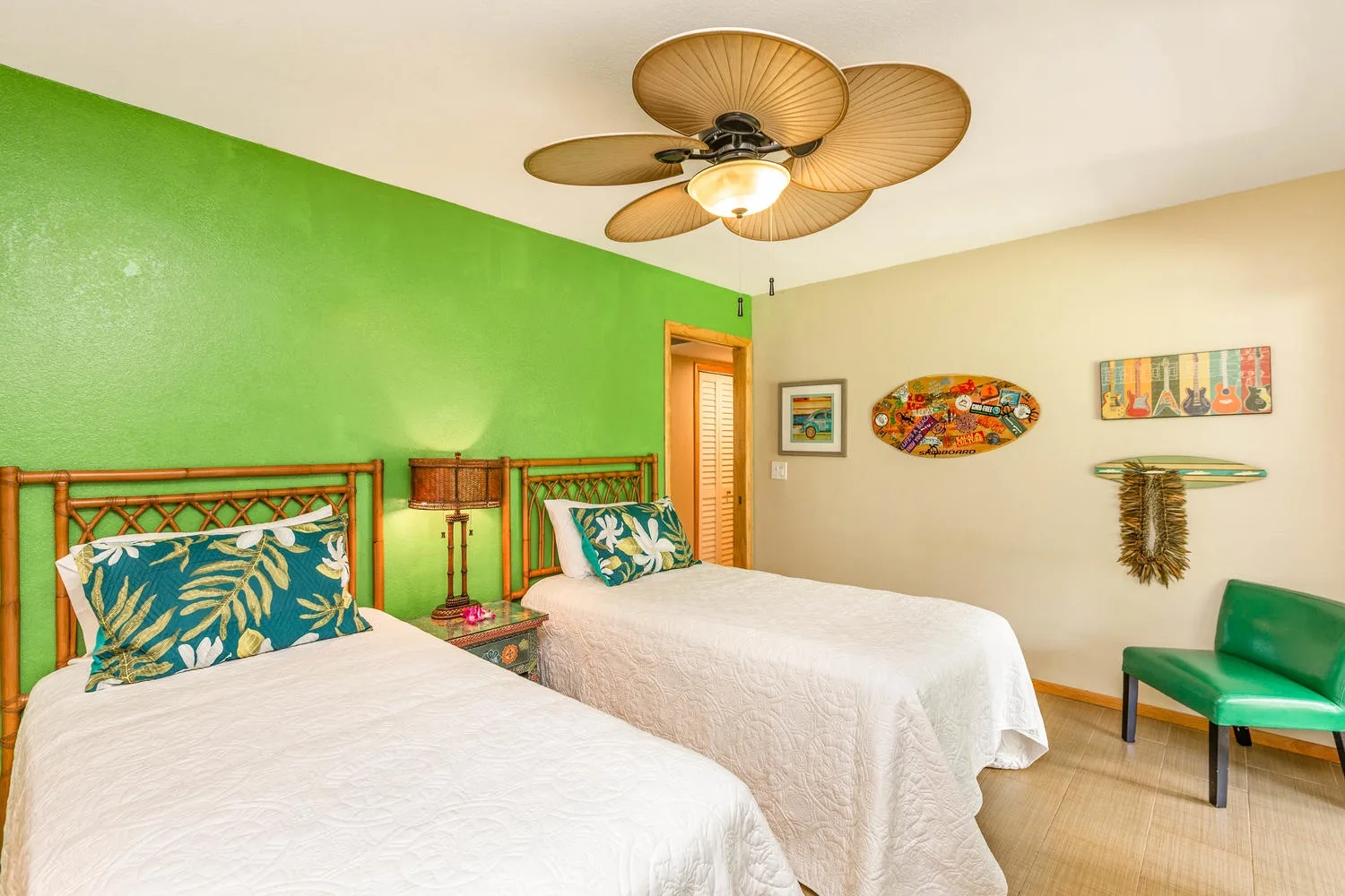 Un dormitorio con dos camas, paredes verdes y coloridas decoraciones en la pared.