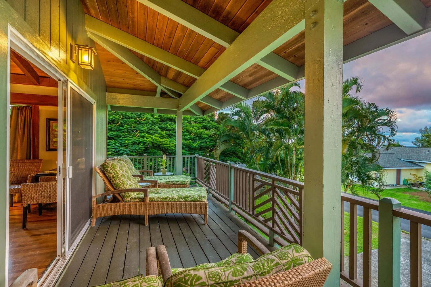 Una terraza cubierta de madera con asientos da a la vegetación tropical y la costa.