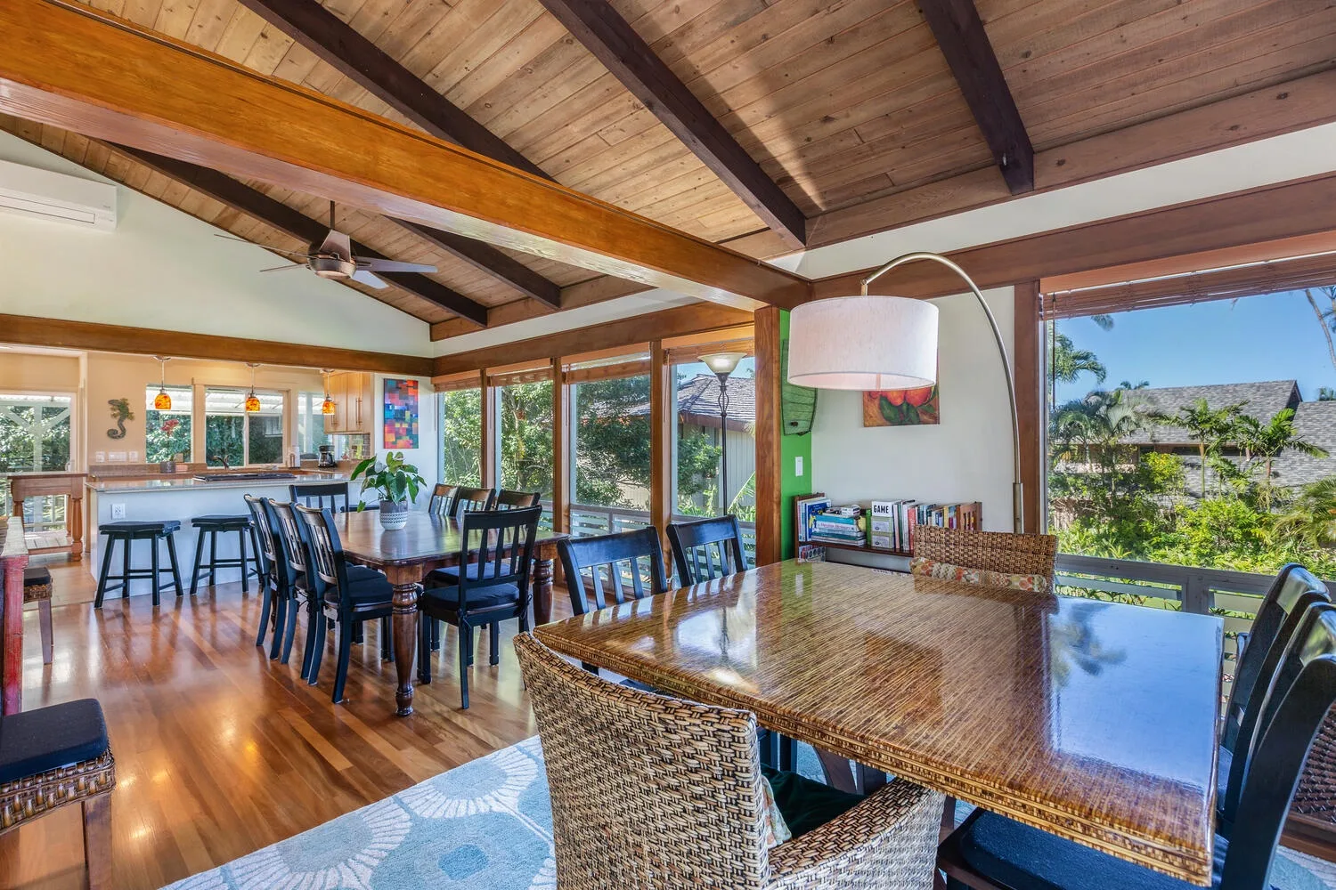 Un comedor luminoso con una larga mesa de madera y grandes ventanas.