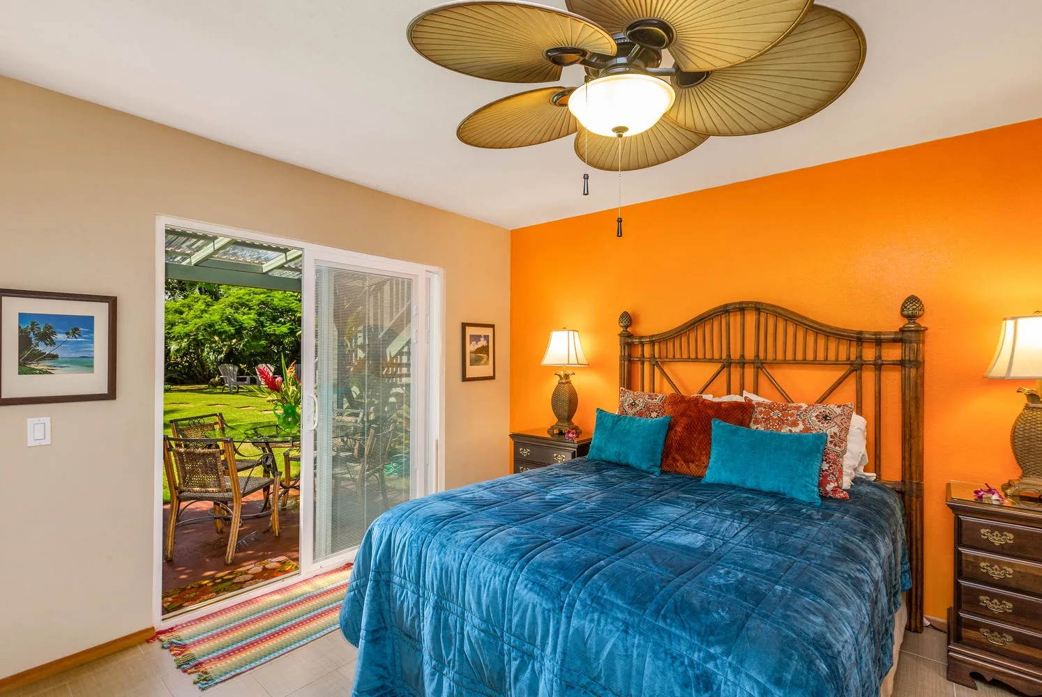 Un dormitorio con una cama grande frente a una pared naranja brillante.