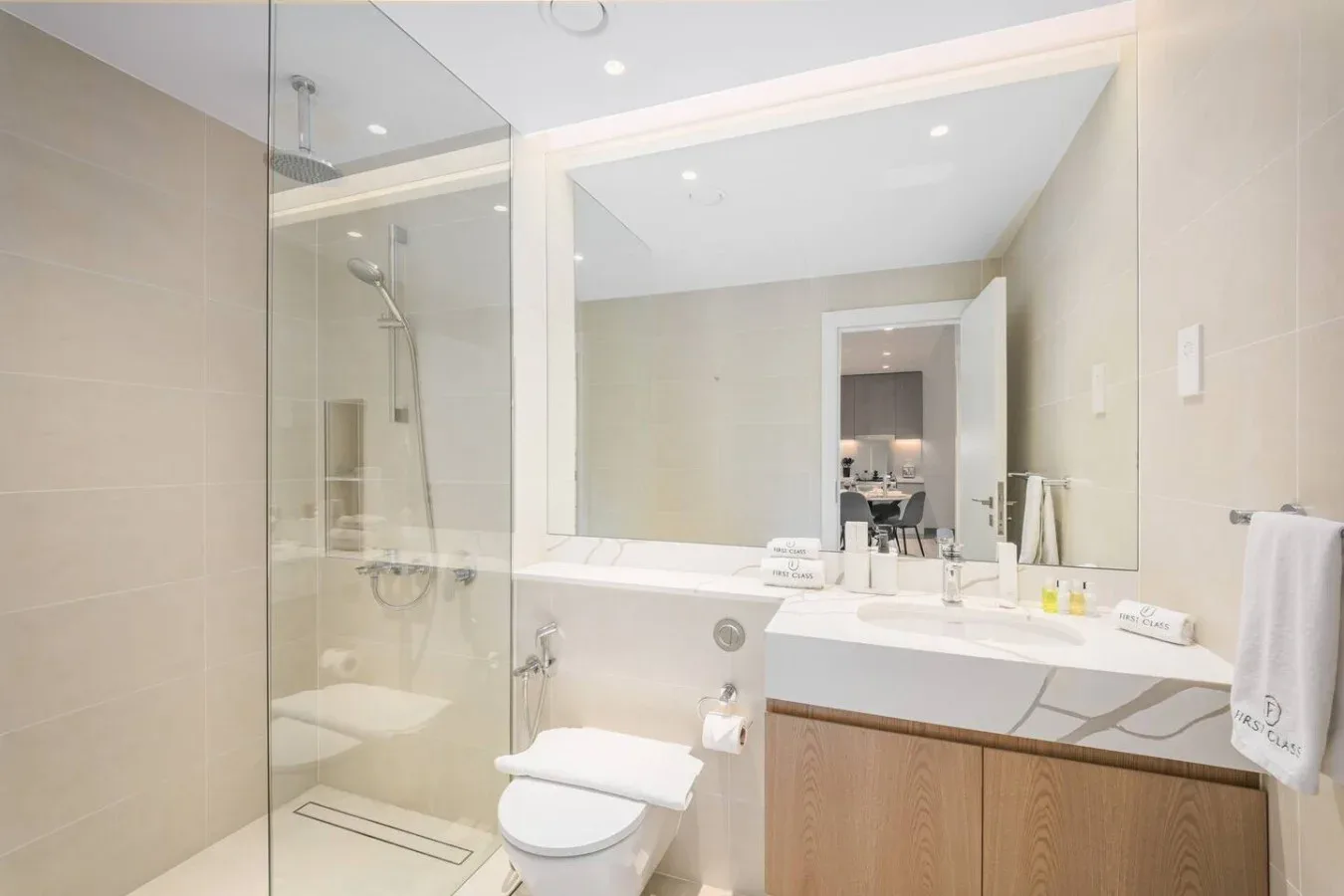 Un baño luminoso con ducha de vidrio, bañera y lavabo con mueble.