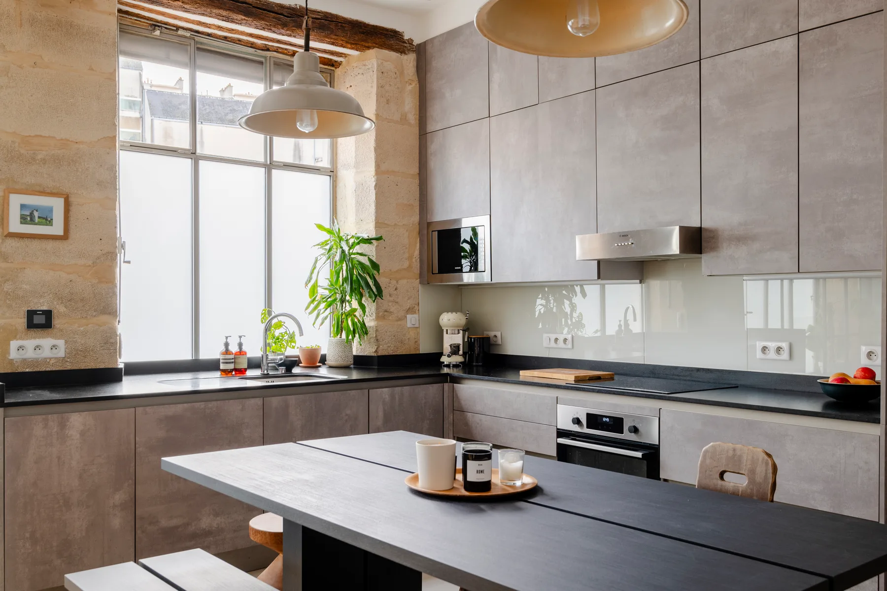 Una cocina moderna con una mesa de comedor y ventanas grandes.