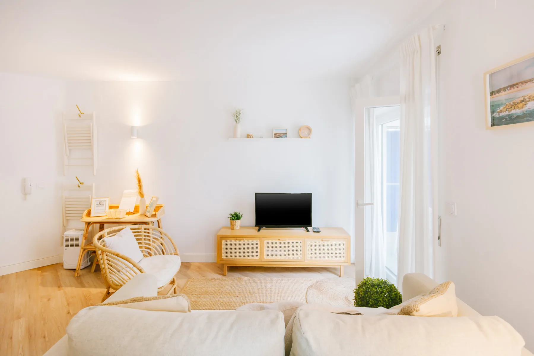 Una sala de estar luminosa con televisión y zona de asientos.