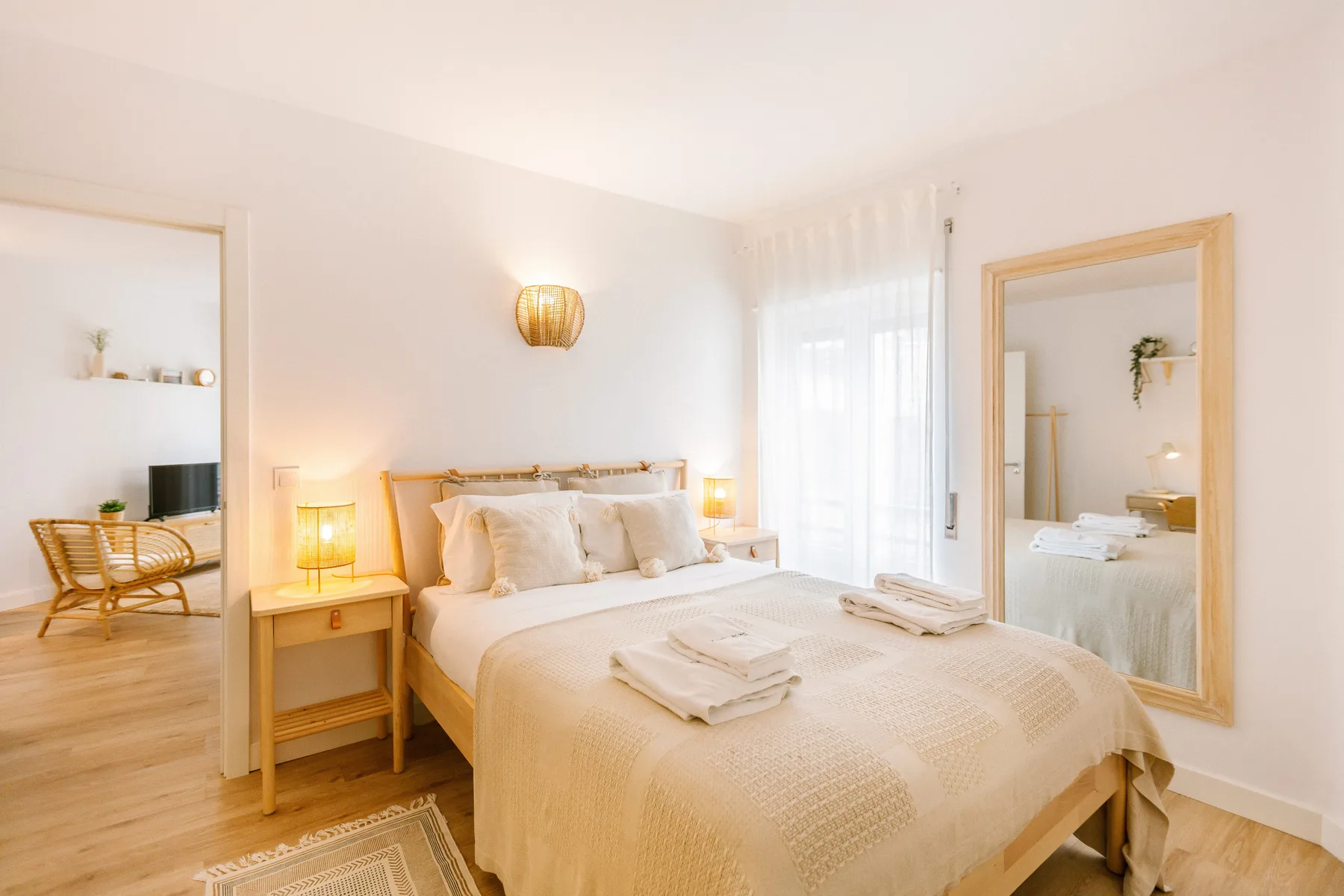 Un dormitorio luminoso con una cama doble y toallas dobladas.