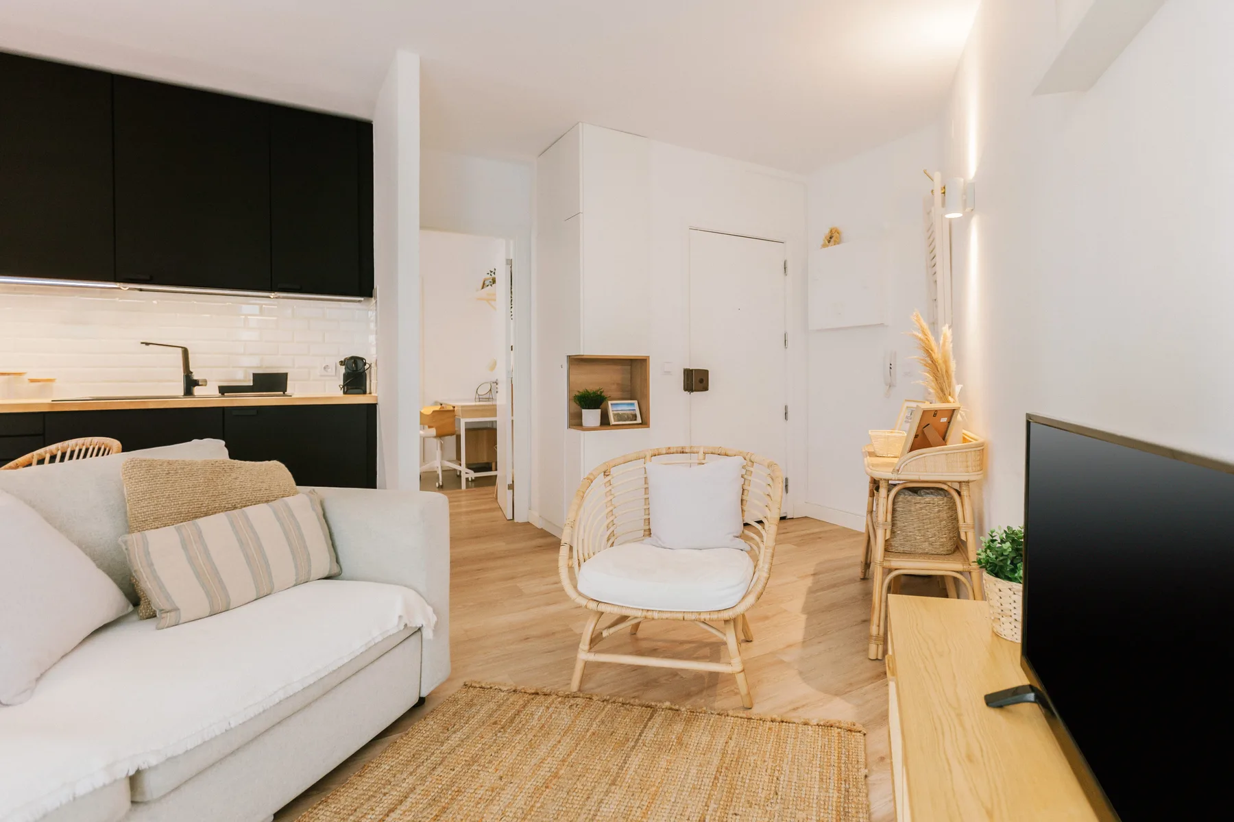 Sala de estar con asientos, un televisor y una pequeña zona de comedor.