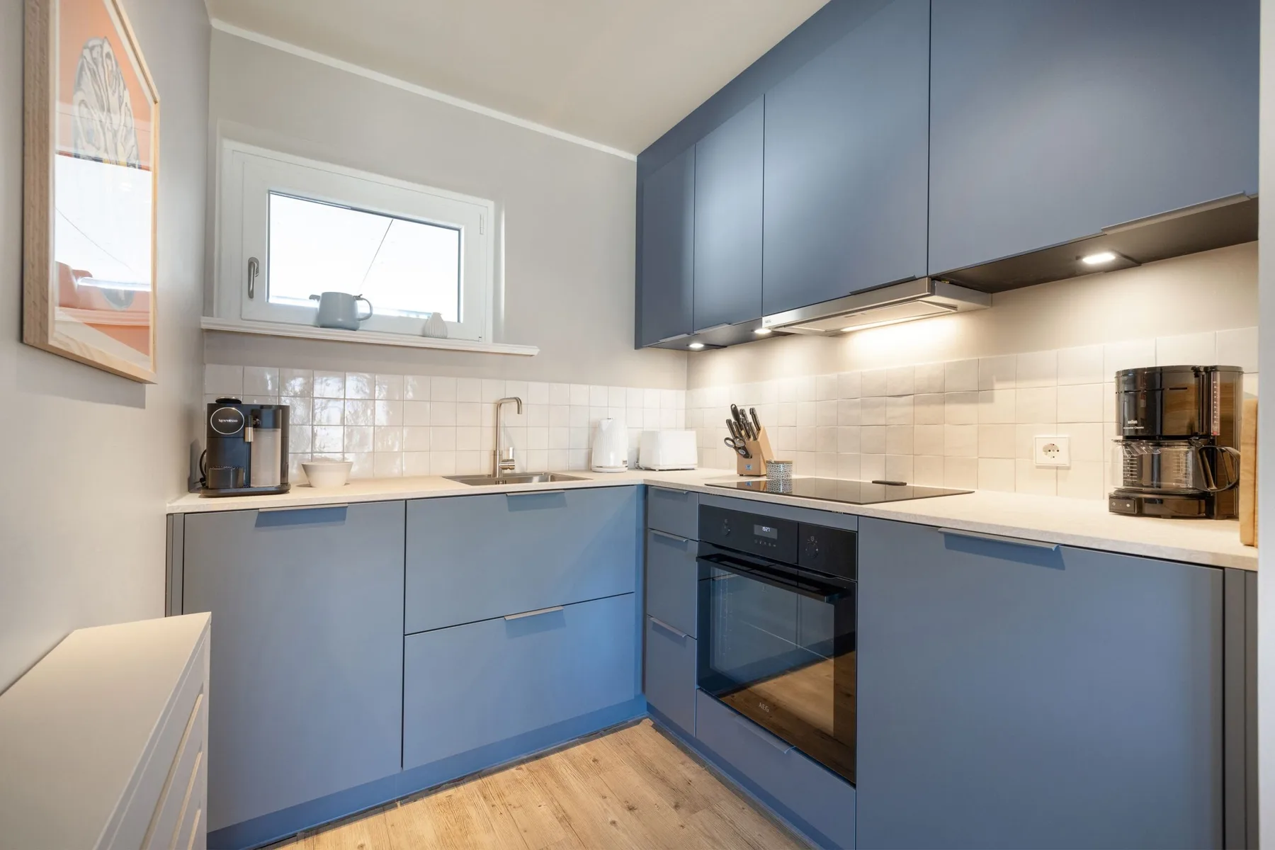 Una cocina moderna con gabinetes azules, una encimera y un horno.