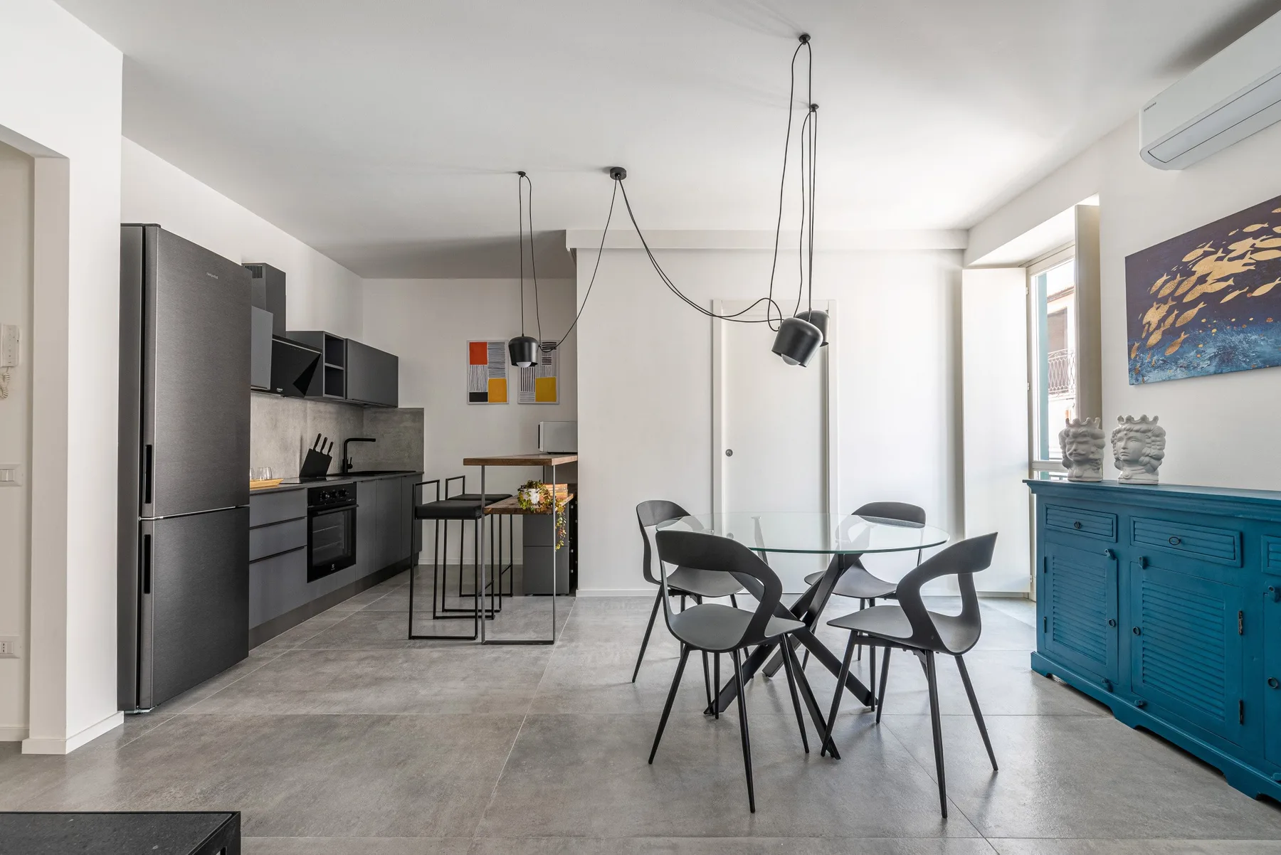 An open-plan kitchen and dining area with a table and chairs.