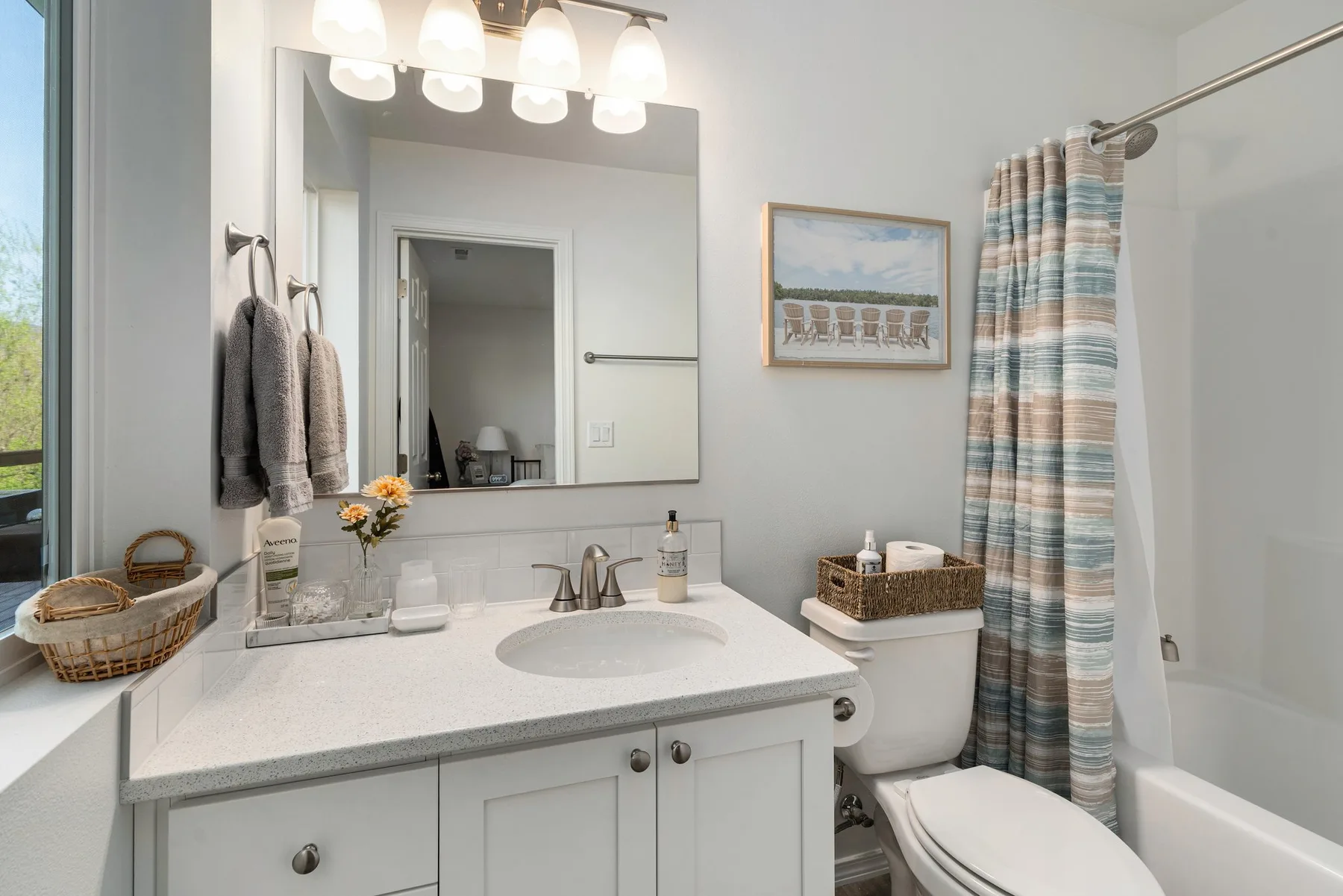 Un lavabo de baño está junto a un inodoro y una bañera con cortina.