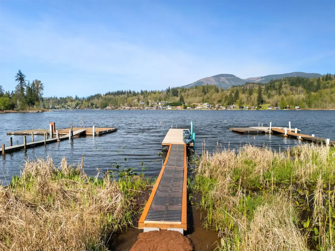 Un muelle junto al lago se extiende entre juncos hacia el agua.