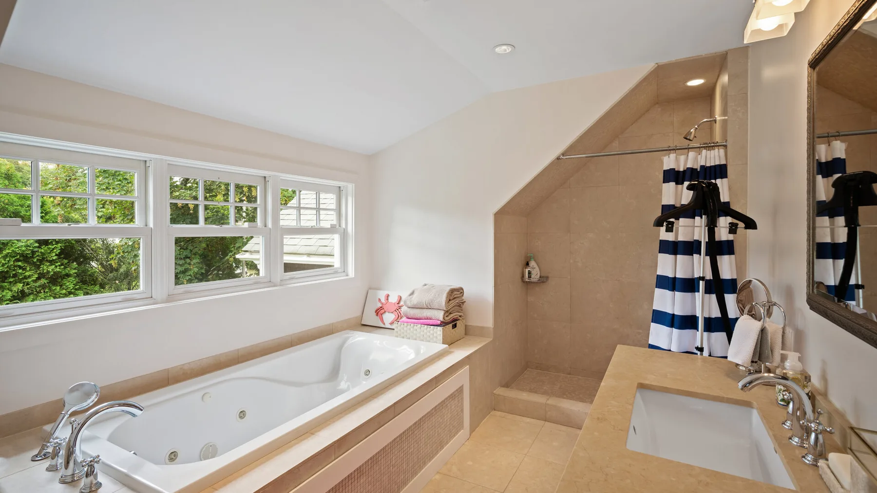 A bright bathroom with a built-in bathtub, a separate shower area, and a sink.