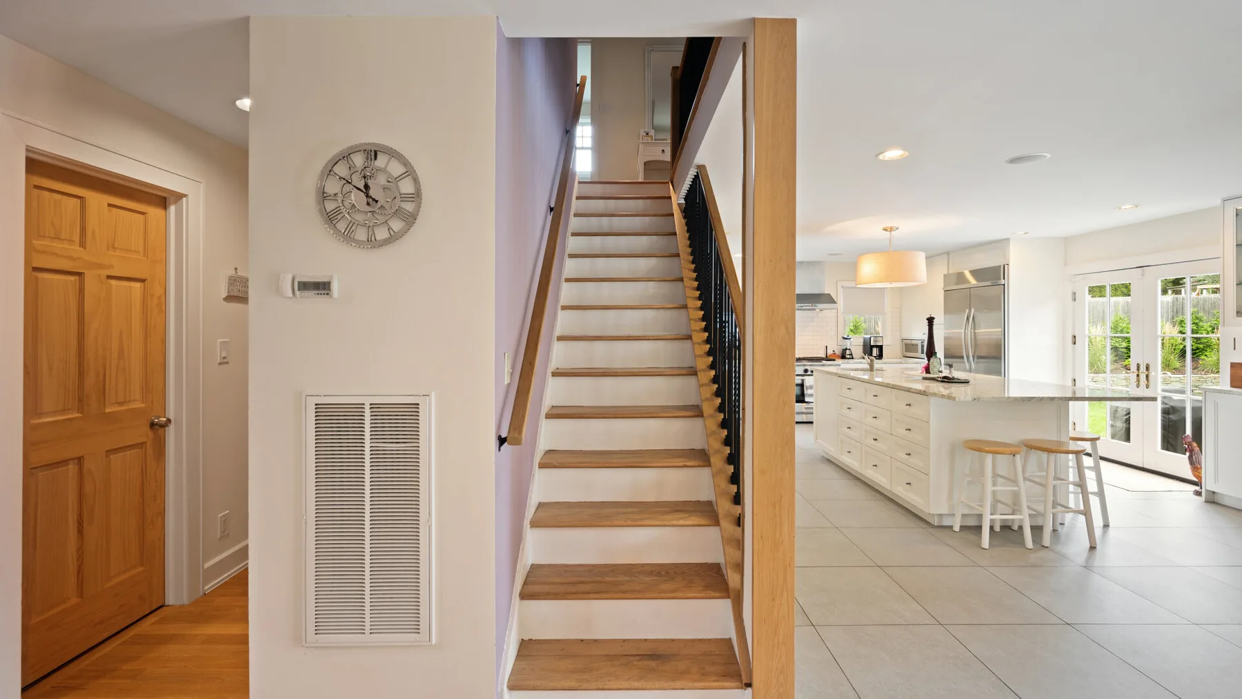 A bright open-plan kitchen and dining area beside a staircase.