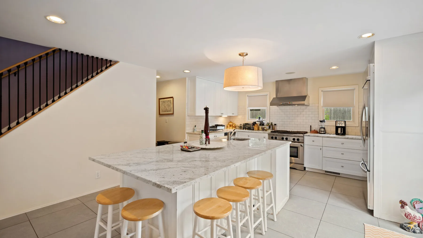 An open kitchen with a large island and a staircase along the wall.