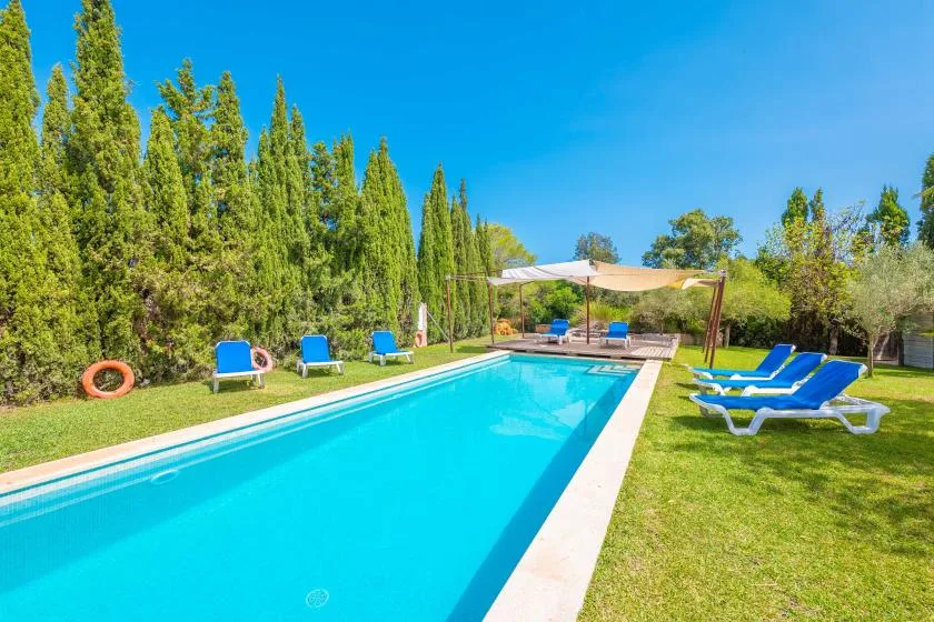 Outdoor swimming pool with lounge chairs on the surrounding lawn.