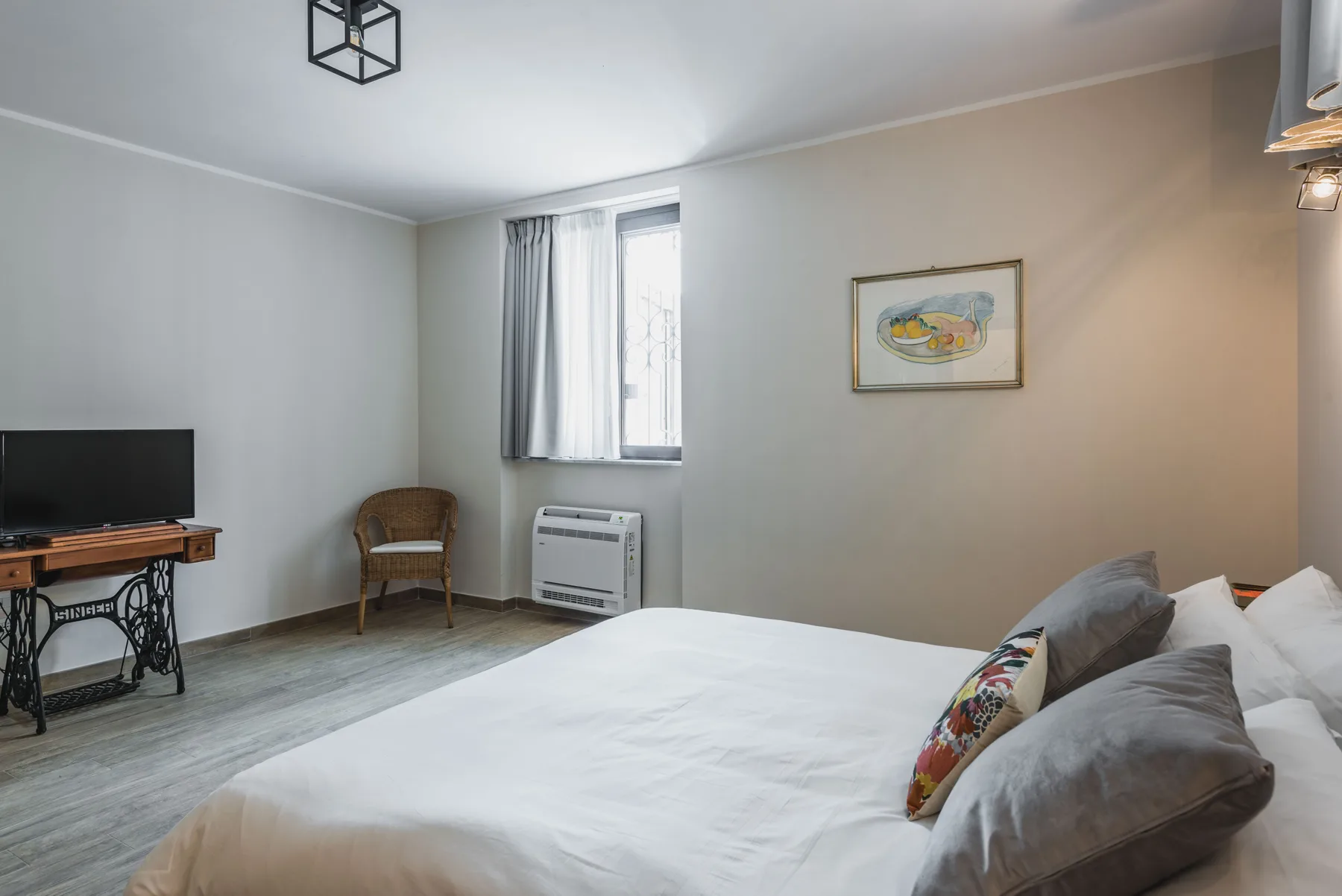 Un dormitorio con una cama grande, una ventana y una pequeña zona de estar.
