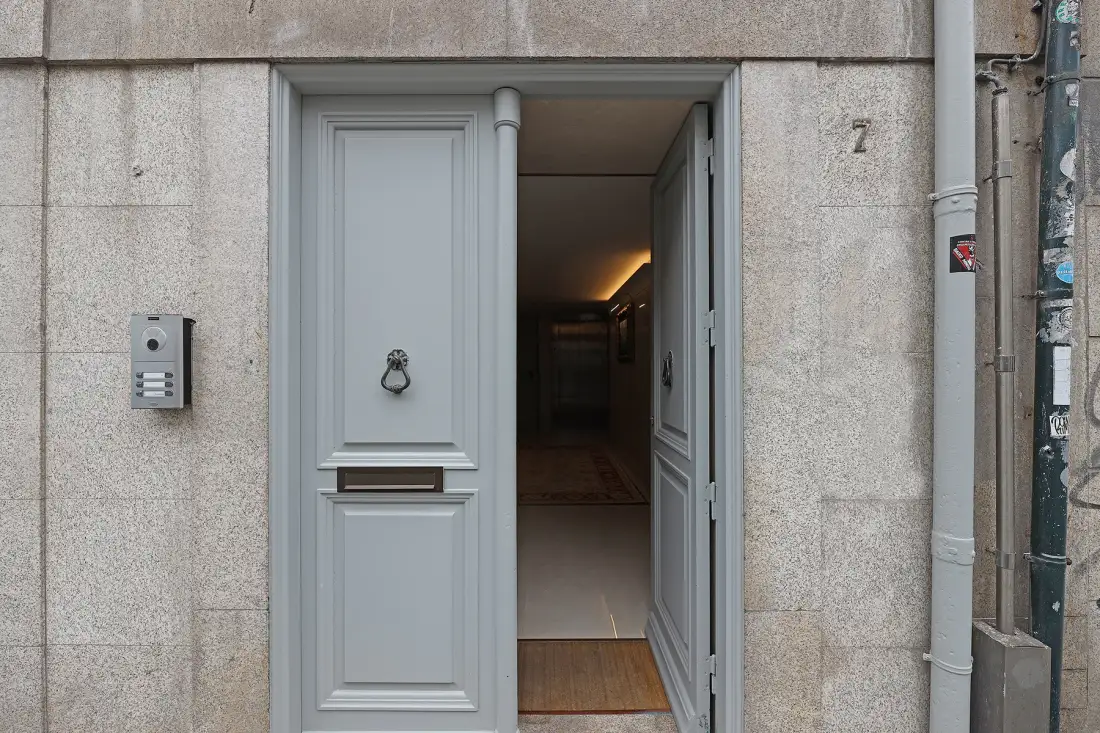 An open gray doorway leads into a dimly lit interior.