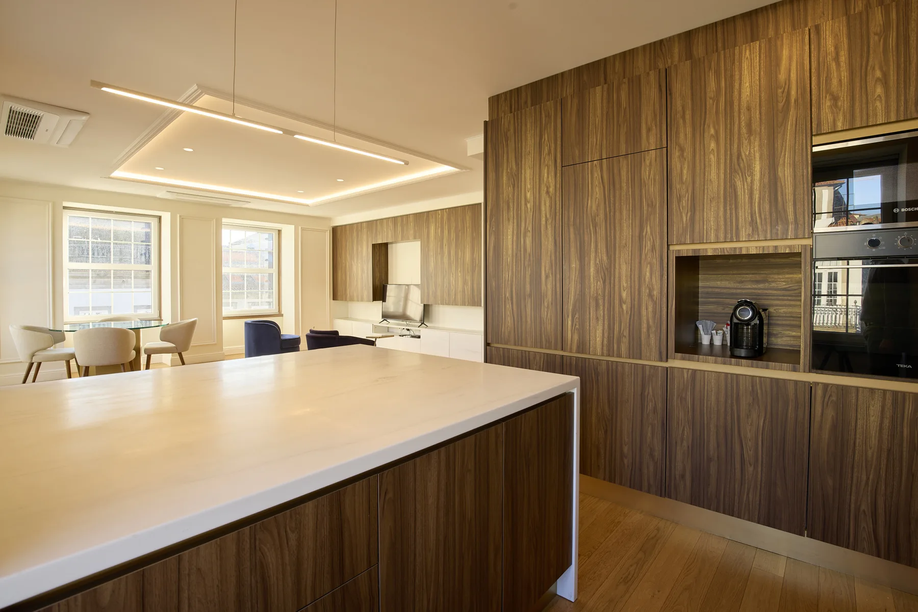 A modern kitchen with a broad island and built-in appliances.