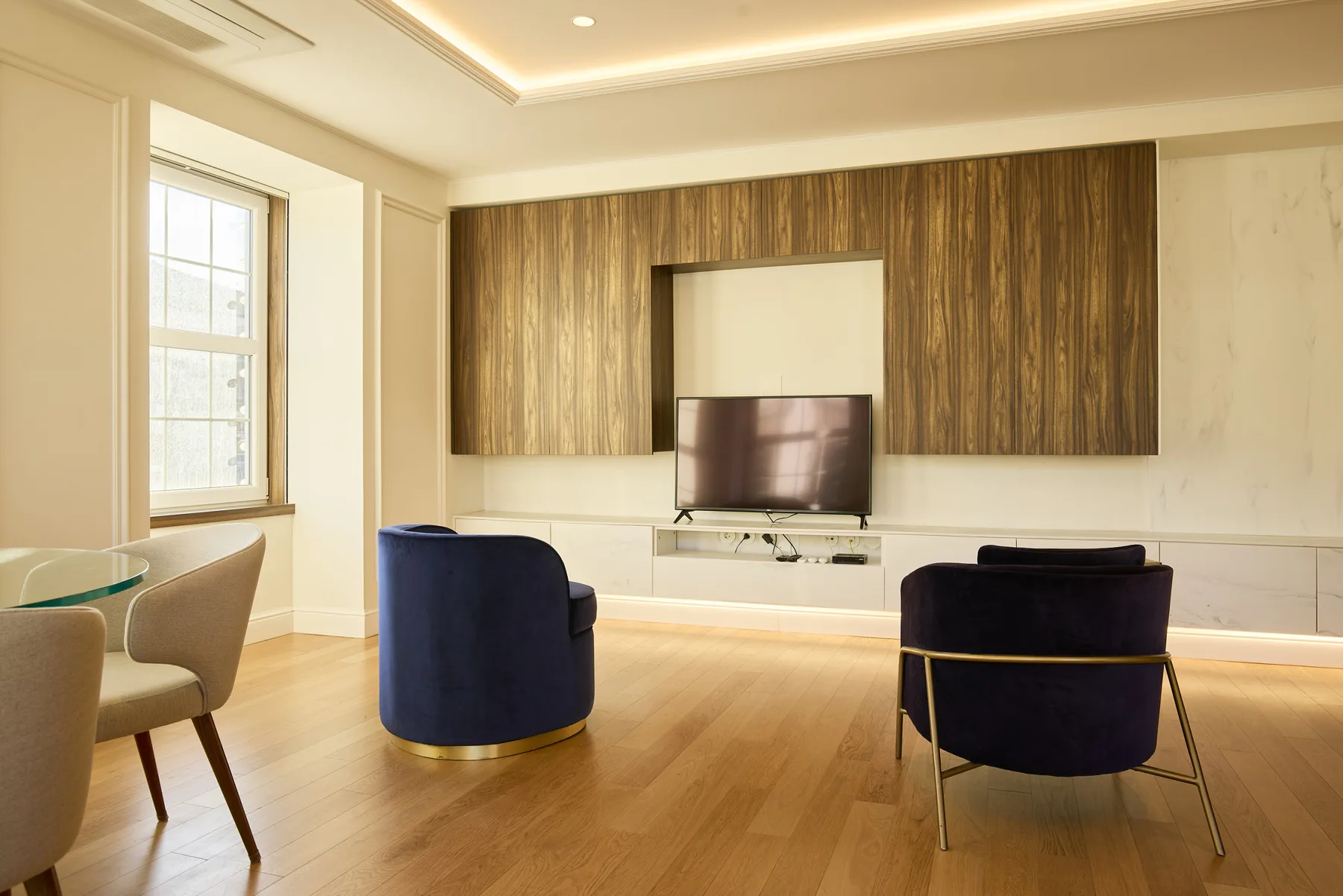 Living room with a television, seating, and a dining area.