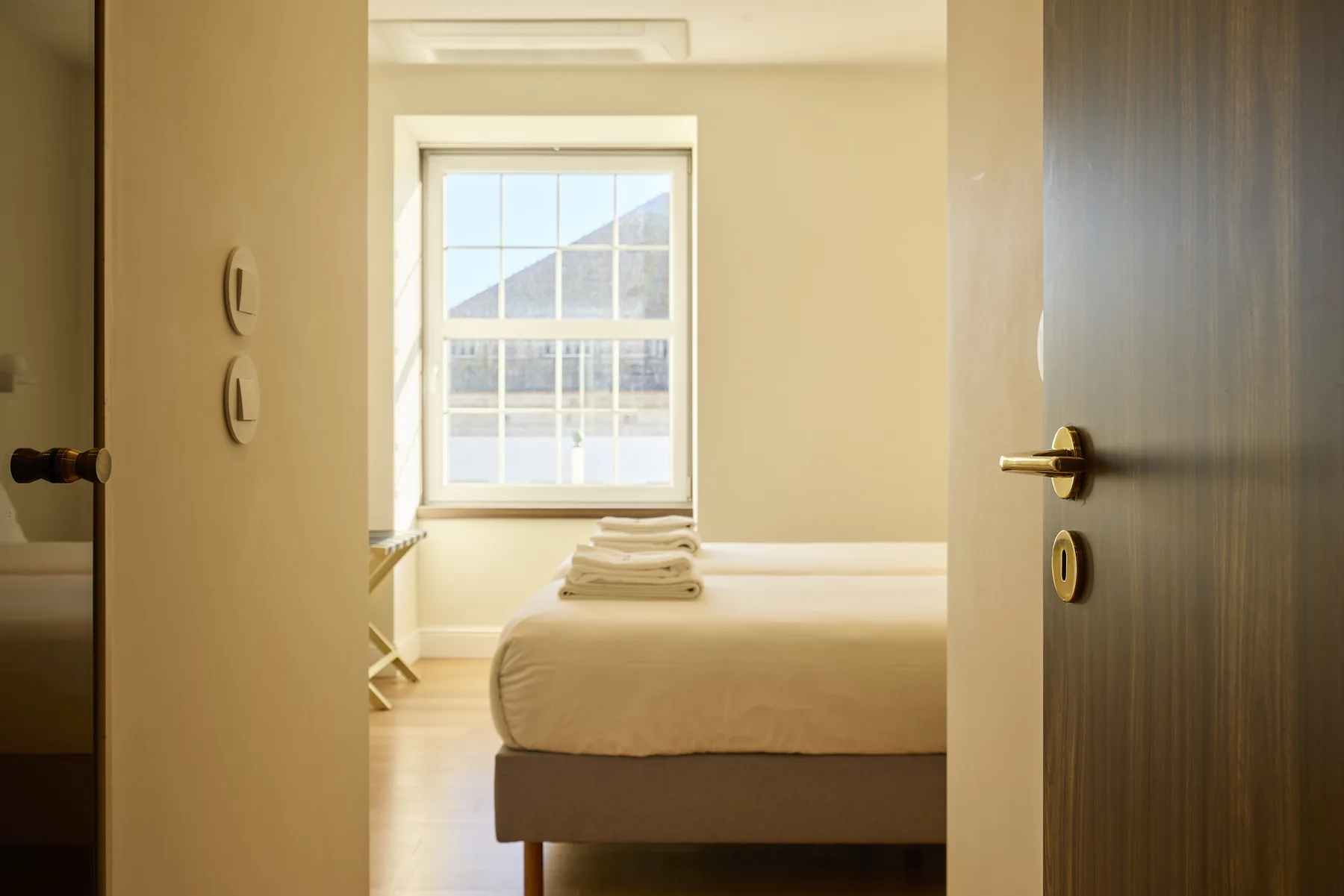 A bedroom with a bed beneath a bright window.