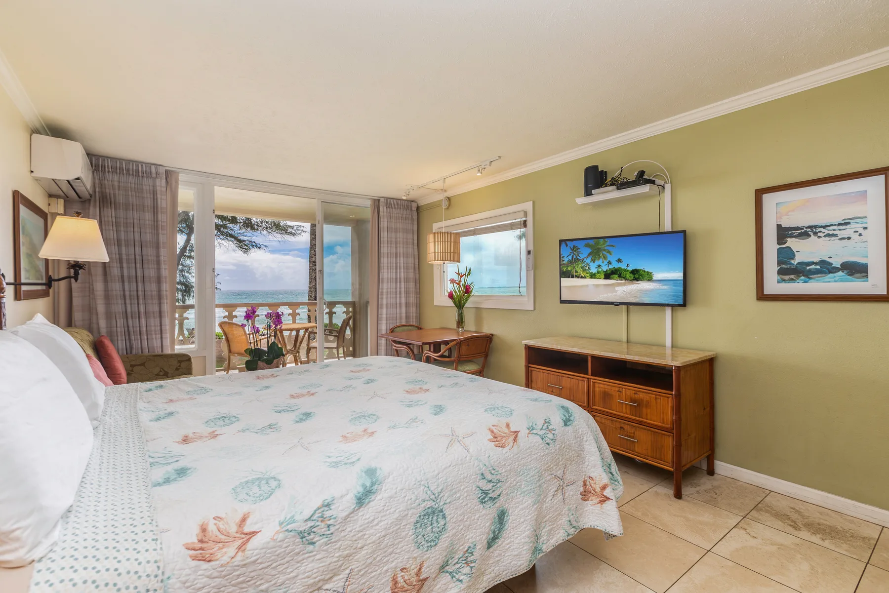 Dormitorio con una cama grande y puertas corredizas de vidrio con vista al mar.