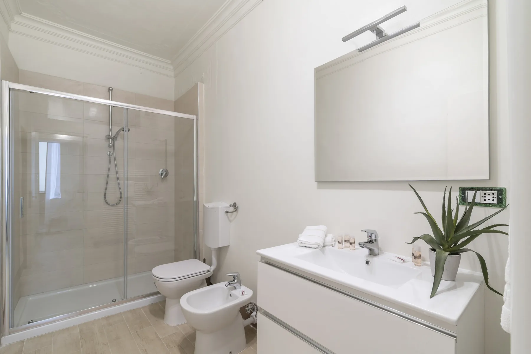 Un baño con ducha de vidrio y un lavabo con mueble.