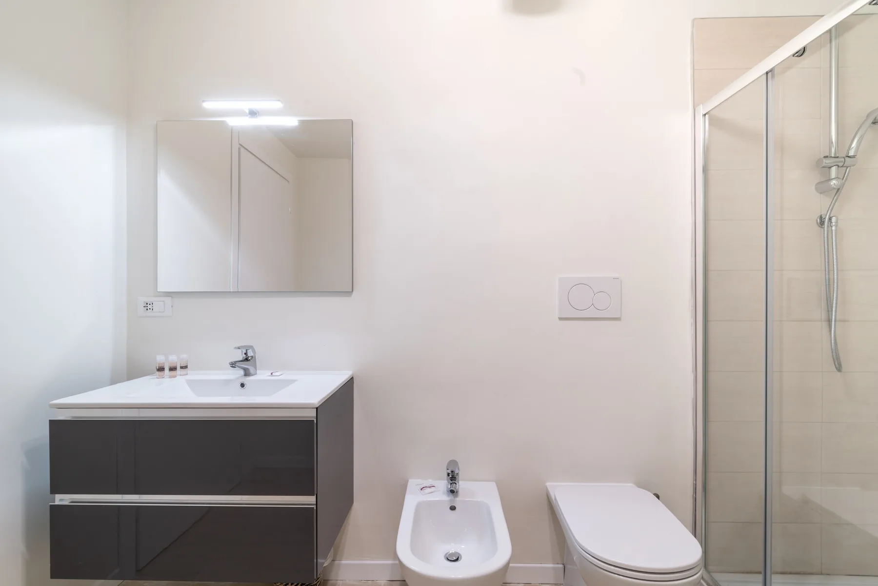 Un baño con lavabo, bidé, inodoro y ducha de vidrio.