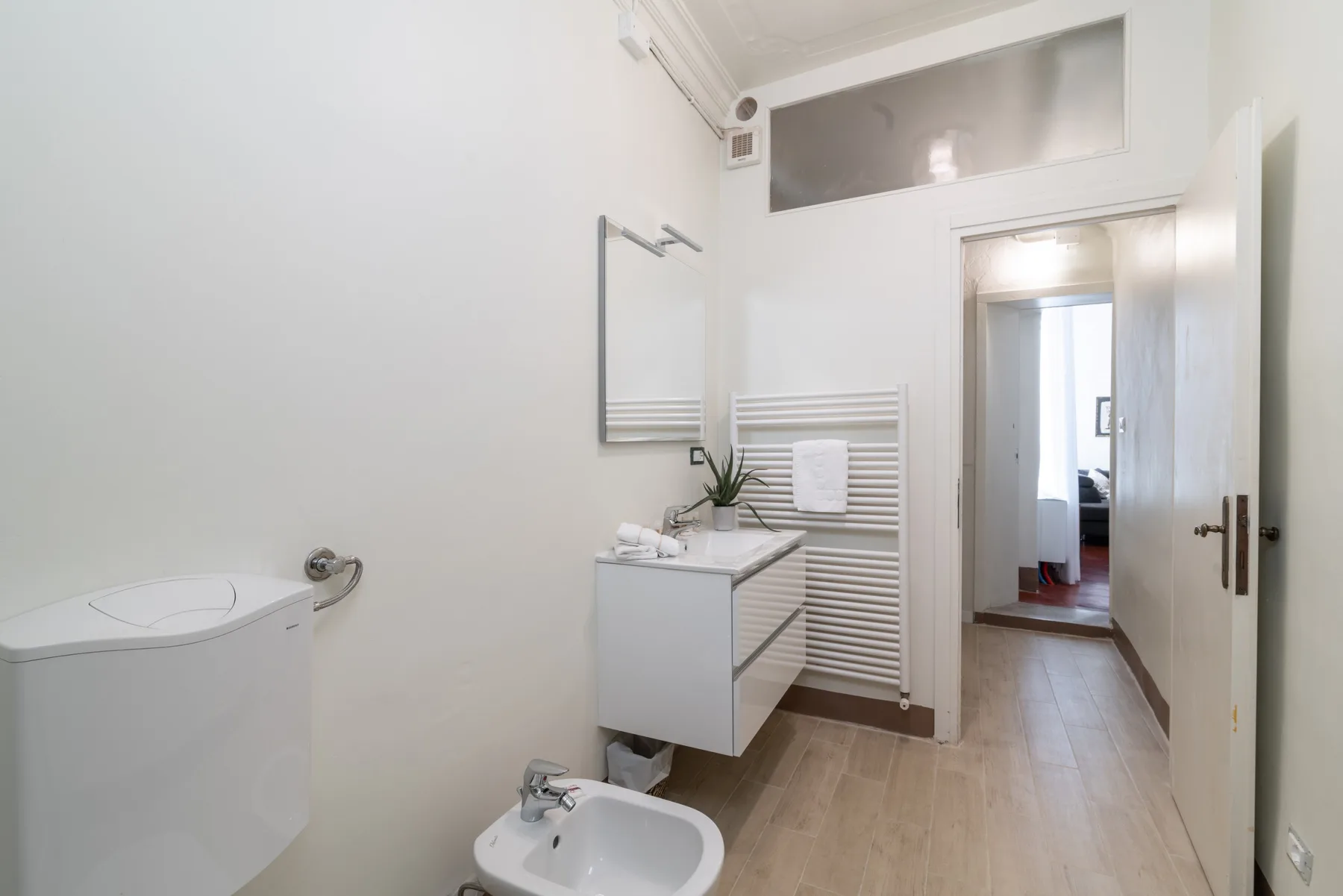 Un baño luminoso con lavabo, espejo de pared y bidé.