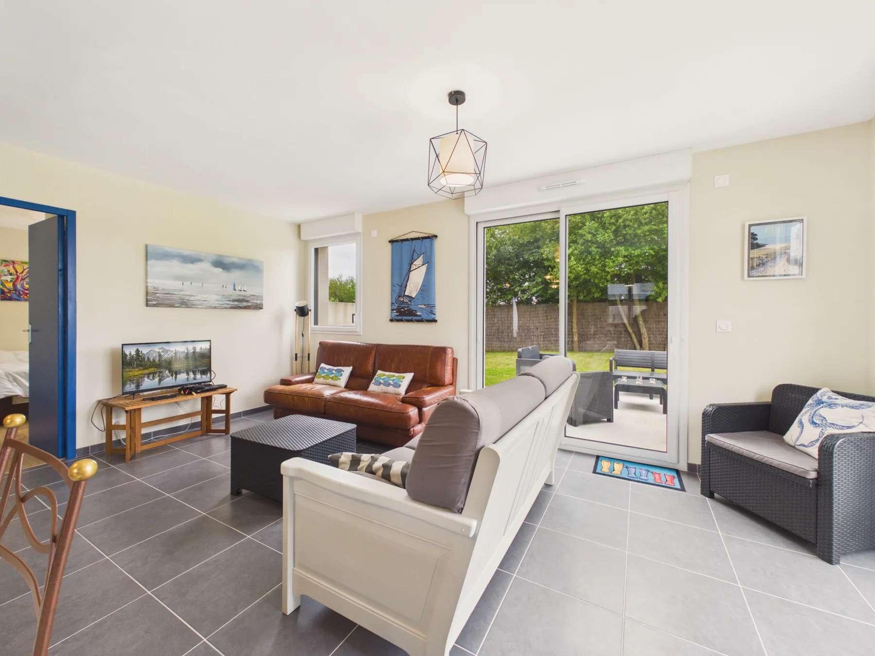 A living room with seating arranged around a low coffee table and sliding glass doors.