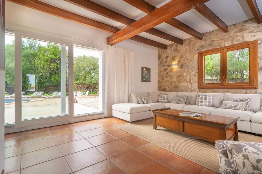 A bright living room with a sectional seating area and large glass doors opening to a patio.