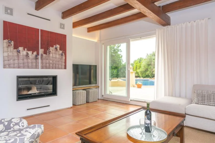 A bright living room opens onto a patio through large glass doors.