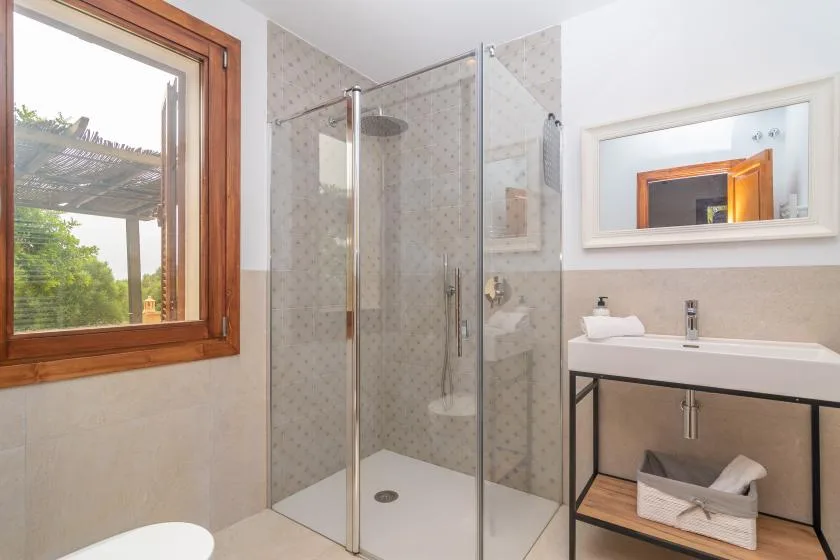 A bathroom with a glass shower and a sink vanity.