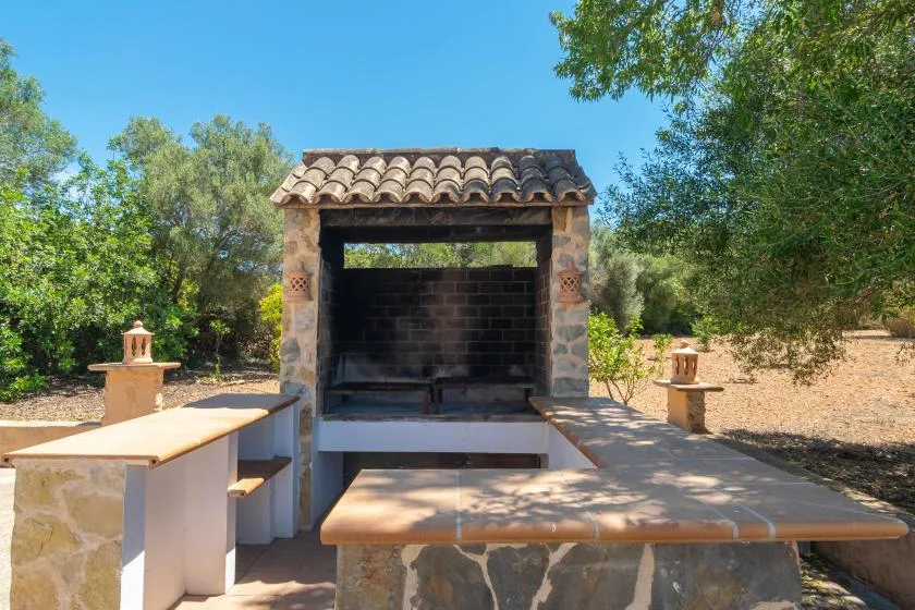 An outdoor cooking area with a built-in barbecue and stone counters.