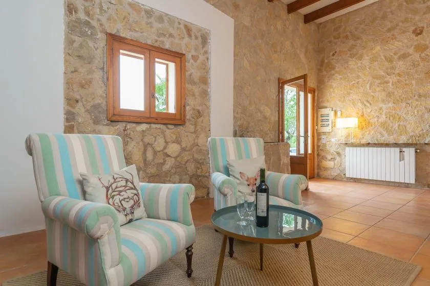 A sitting area with striped armchairs and a round glass coffee table.