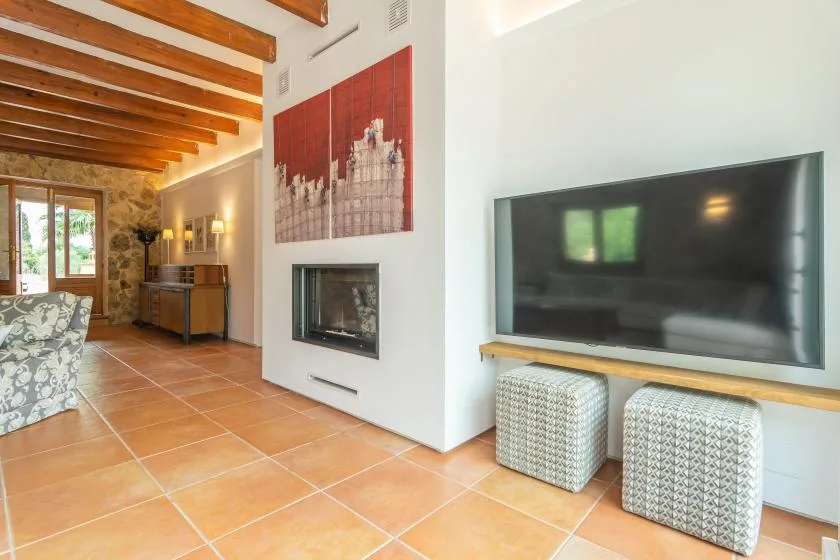 A living room with a wall-mounted television and a fireplace.