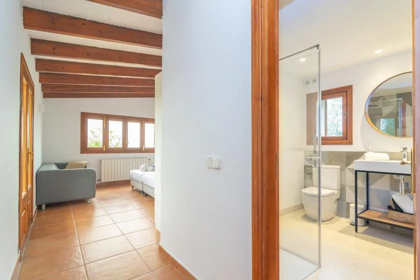 A bedroom and adjoining bathroom are visible through an open doorway.