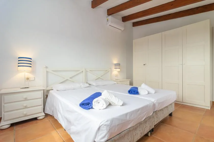 A bright bedroom with a double bed, bedside tables, and built-in wardrobes.